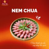 Các thanh Nem Chua Gia An được gói bằng lá chuối xanh mướt, buộc dây chỉ đỏ truyền thống. Bên ngoài là bao bì trong suốt, giúp nhìn rõ từng chiếc nem hồng tươi, điểm xuyết những thớ tỏi trắng và lát ớt đỏ mỏng. Tất cả được sắp xếp gọn gàng, tạo cảm giác tươi mới – thủ công – an toàn vệ sinh. Nhãn dán nổi bật logo Gia An cùng cam kết không chất bảo quản, tôn vinh hương vị quê nhà nguyên bản.